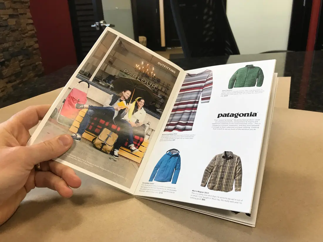 Hand holding an open Patagonia retail catalogue booklet
