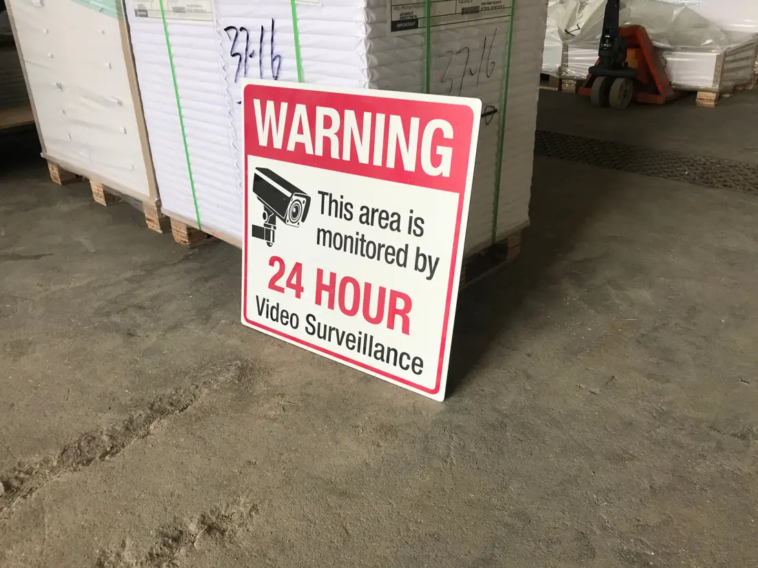 A video surveillance warning sign on aluminum